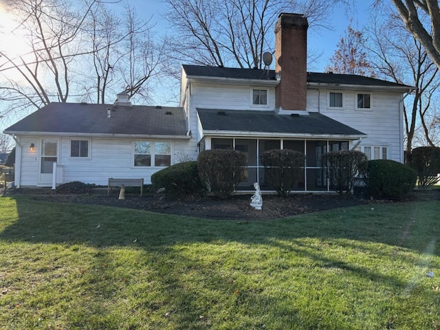 rear view of house with a yard and a sunroom