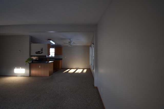 kitchen featuring dark colored carpet, kitchen peninsula, and ceiling fan