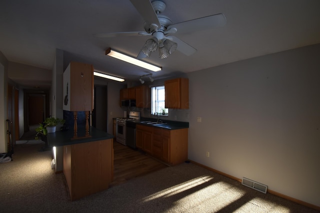 kitchen featuring dark colored carpet, white gas stove, ceiling fan, and sink