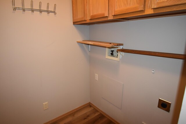 laundry room with hookup for a washing machine, cabinets, wood-type flooring, and electric dryer hookup