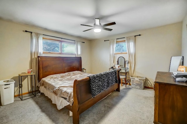 bedroom with multiple windows, ceiling fan, and light colored carpet