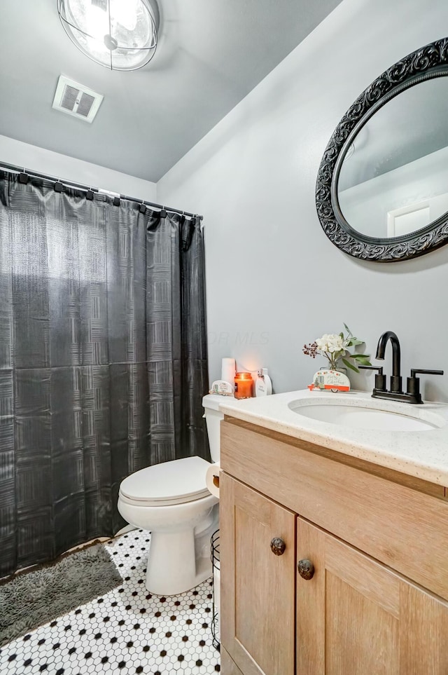 bathroom with tile patterned flooring, vanity, a shower with shower curtain, and toilet