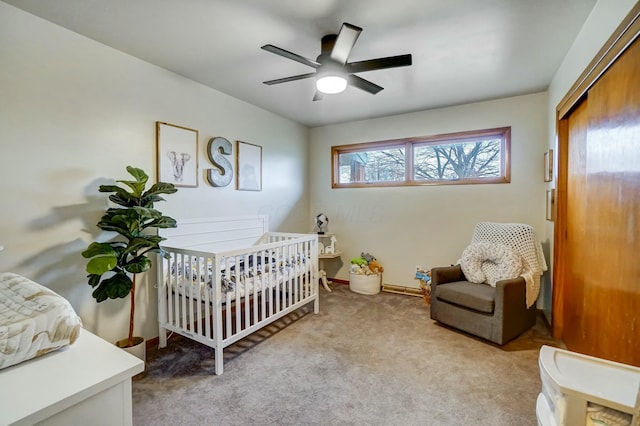 bedroom featuring ceiling fan, a closet, light carpet, and a nursery area