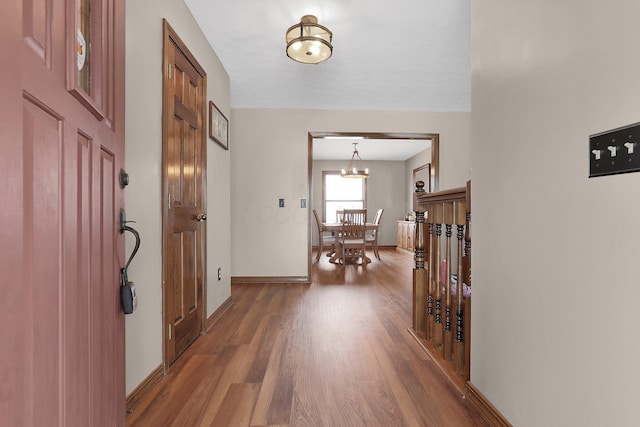 hallway featuring hardwood / wood-style flooring and a notable chandelier