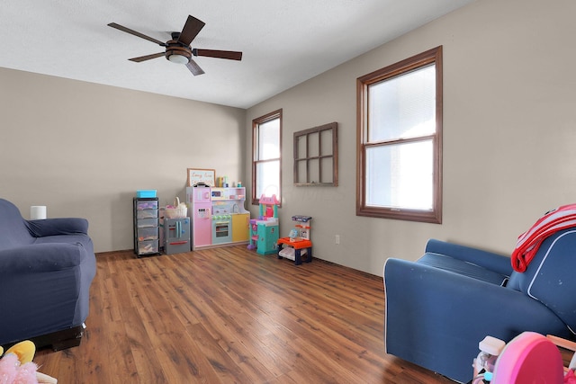 rec room with ceiling fan, dark hardwood / wood-style flooring, and a textured ceiling