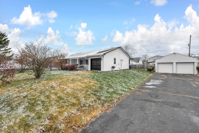 view of property exterior with a garage, a yard, and an outbuilding