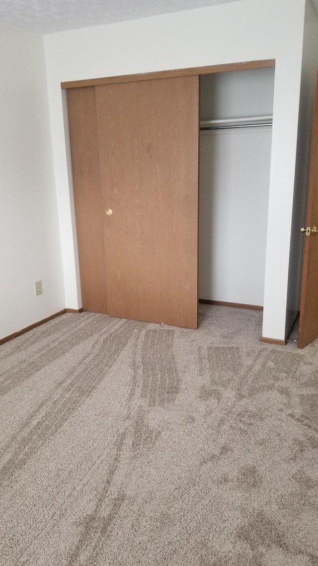 unfurnished bedroom with carpet floors and a closet