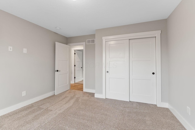 unfurnished bedroom featuring carpet flooring and a closet