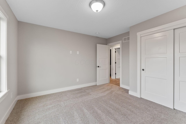 unfurnished bedroom with carpet and a closet