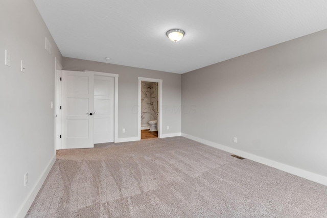 unfurnished bedroom with carpet and ensuite bath