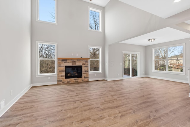 unfurnished living room with a high ceiling and light wood-type flooring