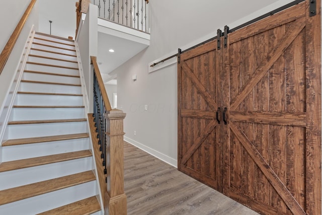 stairs featuring a barn door and wood-type flooring