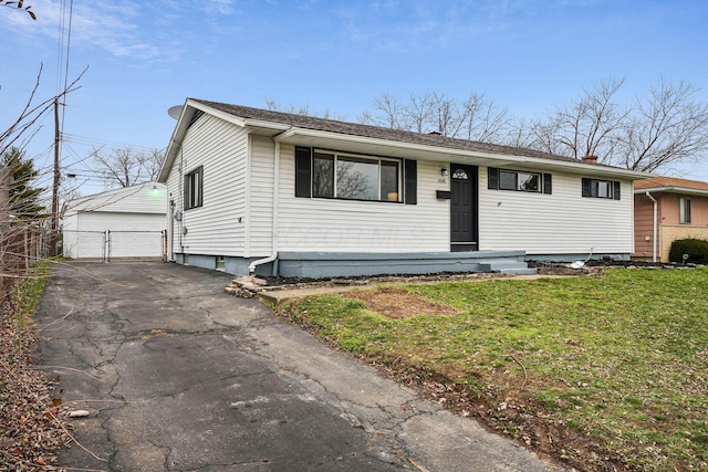 view of front of home featuring an outbuilding, a front lawn, and a garage