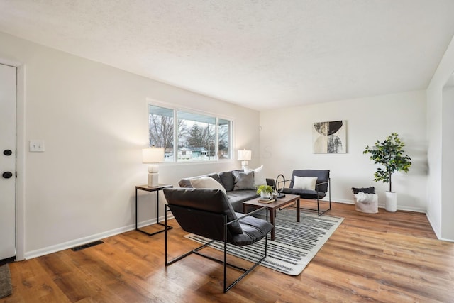 living room with hardwood / wood-style floors and a textured ceiling