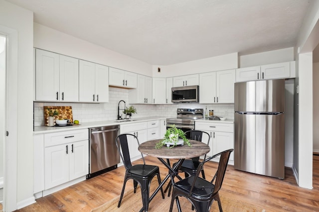 kitchen featuring white cabinets, stainless steel appliances, and light hardwood / wood-style flooring