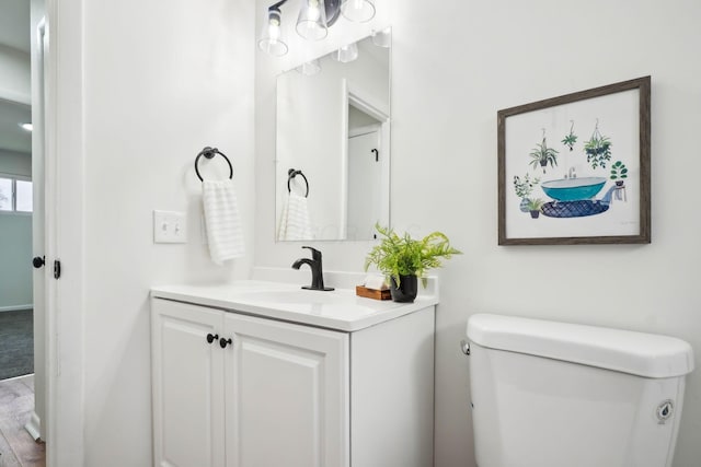 bathroom featuring hardwood / wood-style floors, vanity, and toilet