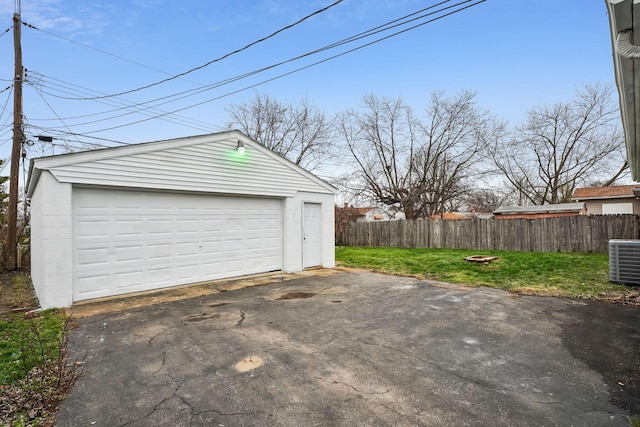 garage featuring cooling unit and a lawn