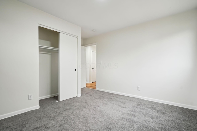 unfurnished bedroom with carpet flooring and a closet