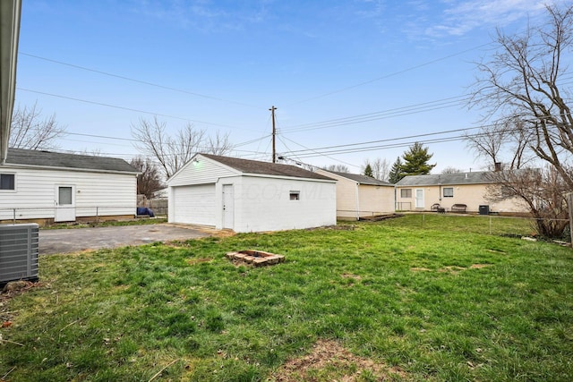 view of yard with central AC, a garage, and an outdoor structure