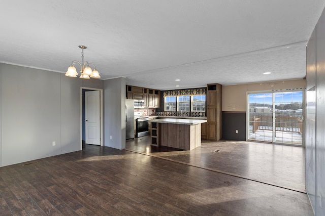 kitchen with hanging light fixtures, stainless steel appliances, dark hardwood / wood-style floors, a chandelier, and a textured ceiling