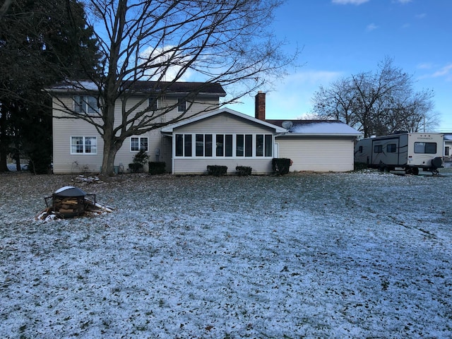 snow covered property featuring a sunroom