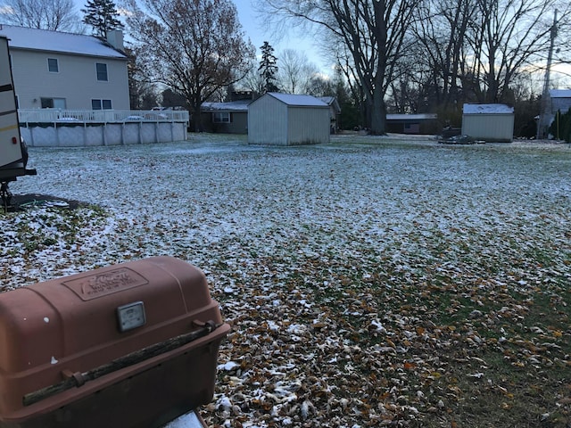 yard layered in snow featuring a shed