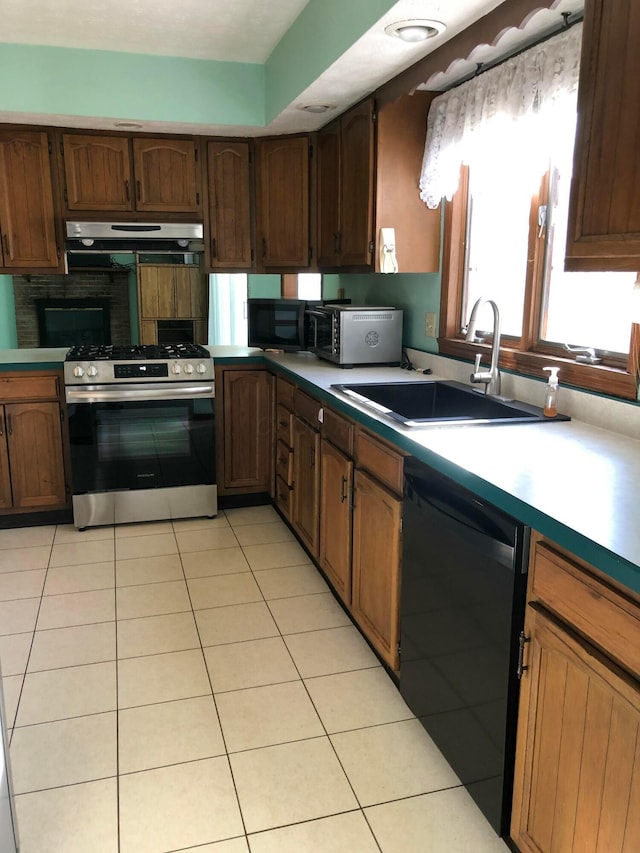 kitchen featuring exhaust hood, sink, light tile patterned floors, and black appliances