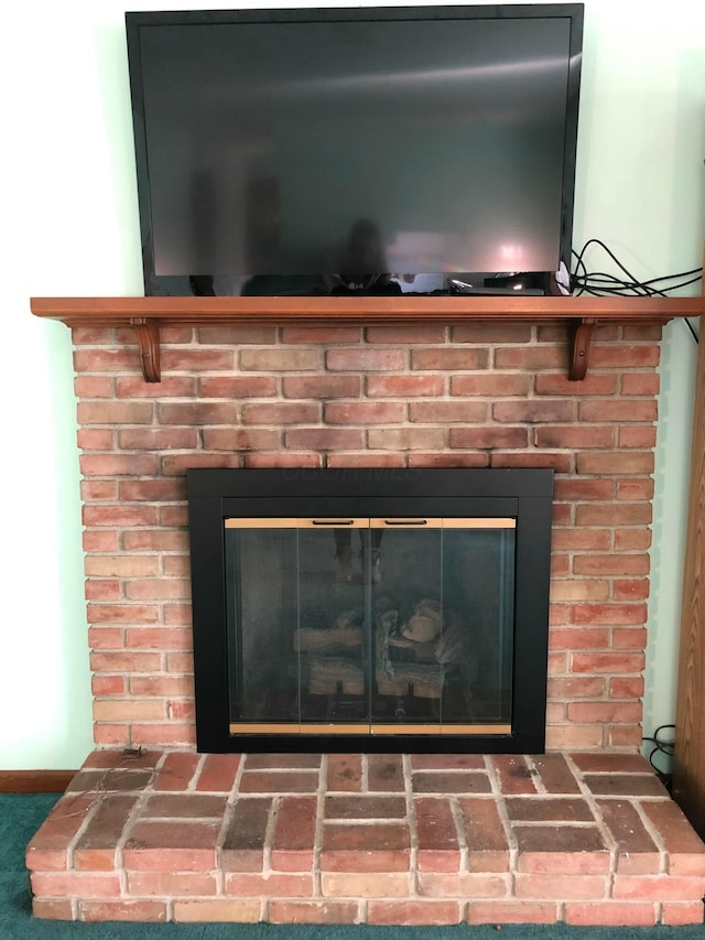 details featuring carpet floors and a brick fireplace