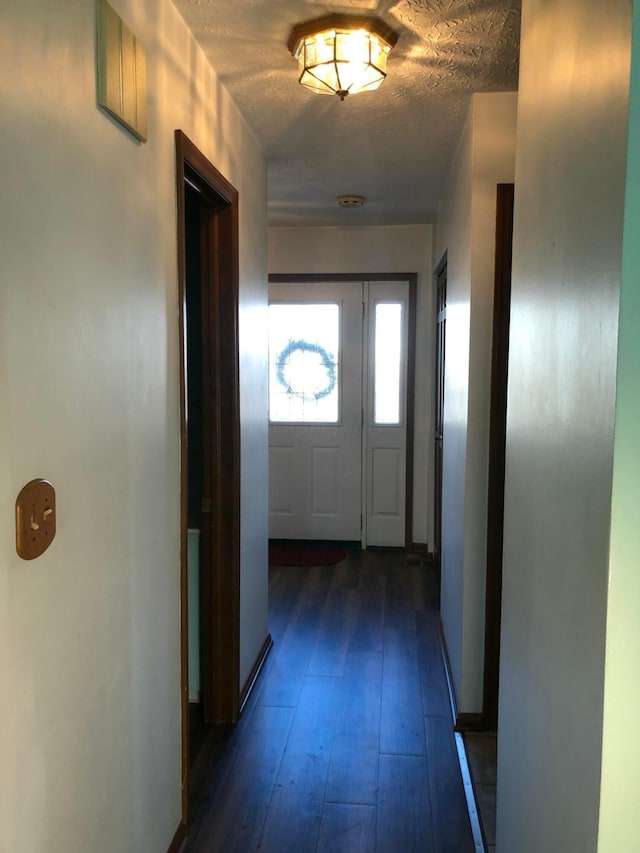 corridor featuring dark hardwood / wood-style floors and a textured ceiling