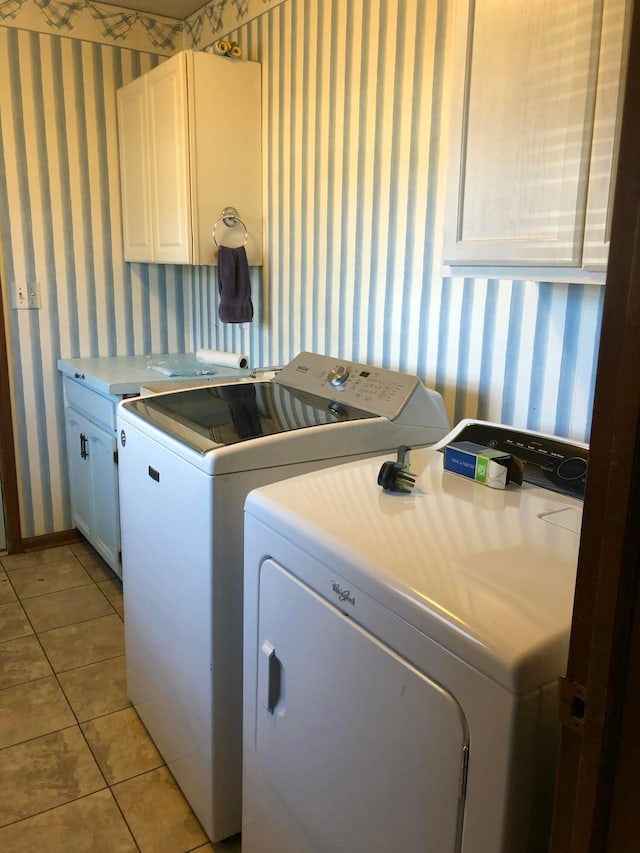 laundry room with cabinets, independent washer and dryer, and light tile patterned floors