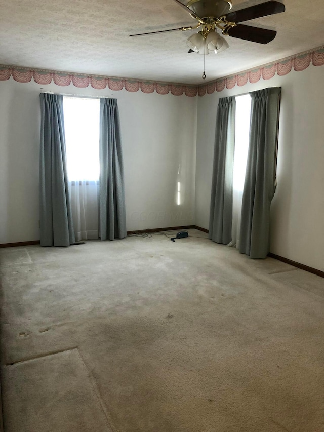 spare room featuring ceiling fan and carpet floors