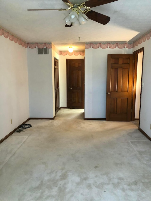 spare room featuring light colored carpet and ceiling fan