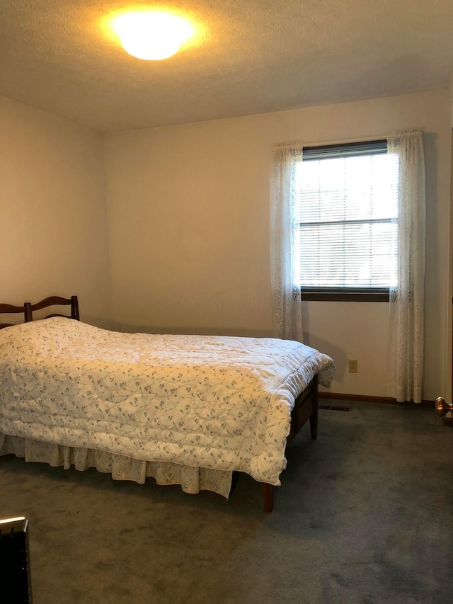 carpeted bedroom with a textured ceiling