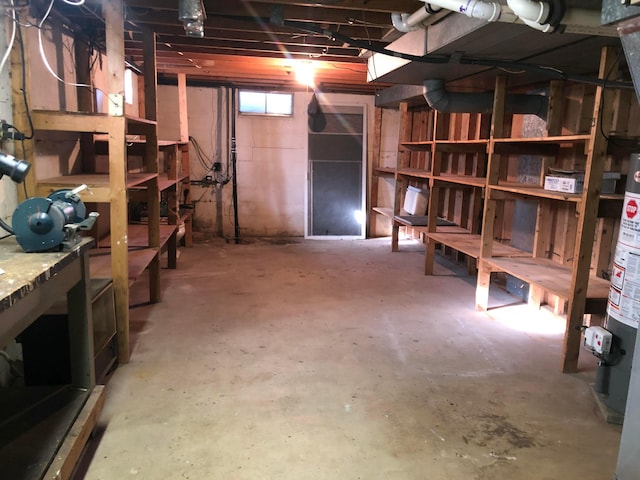 basement with a workshop area and water heater