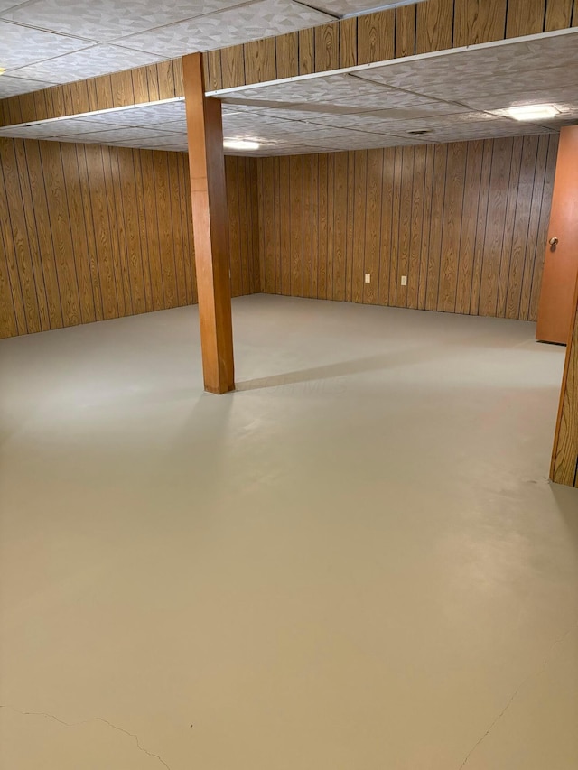 basement featuring wooden walls