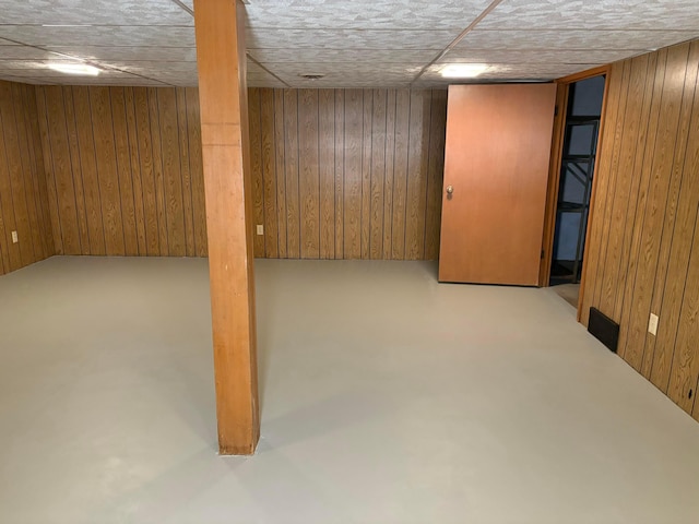 basement featuring wood walls