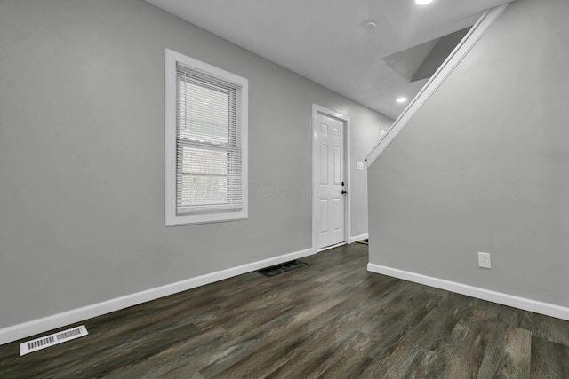 interior space featuring dark wood-style floors, visible vents, and baseboards