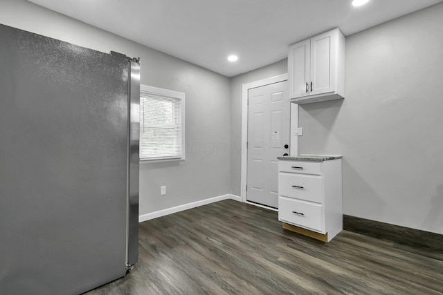 interior space with baseboards, dark wood-style floors, freestanding refrigerator, white cabinetry, and recessed lighting