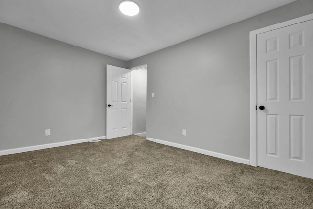 carpeted empty room featuring baseboards