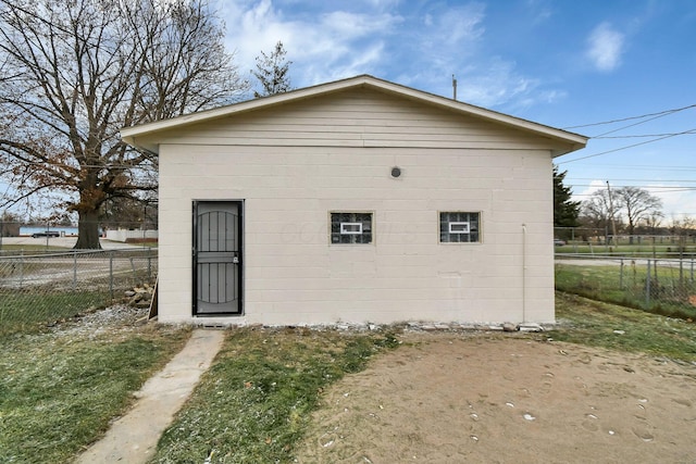 rear view of property featuring fence and an outbuilding