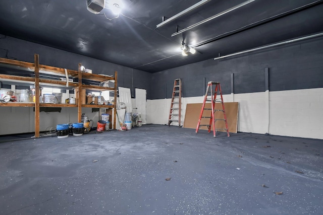 garage featuring a garage door opener and concrete block wall