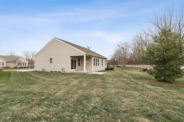 rear view of property featuring a lawn and a patio area