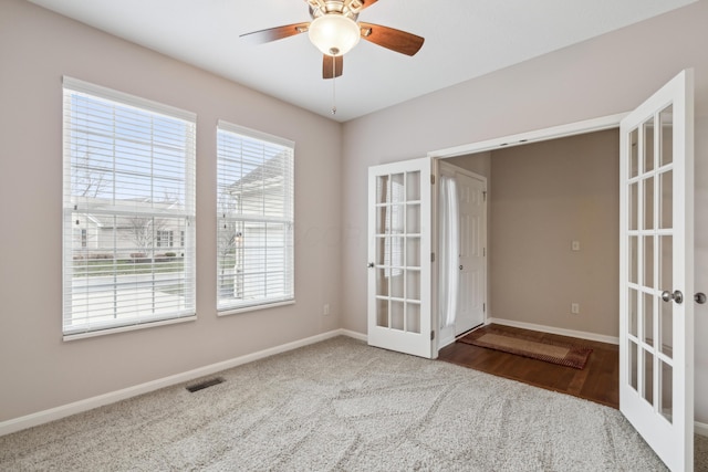 empty room with ceiling fan, french doors, and hardwood / wood-style flooring