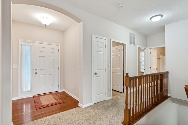 entryway with wood-type flooring and a textured ceiling