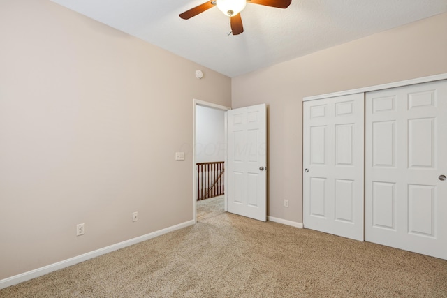 unfurnished bedroom featuring ceiling fan, a closet, and carpet floors