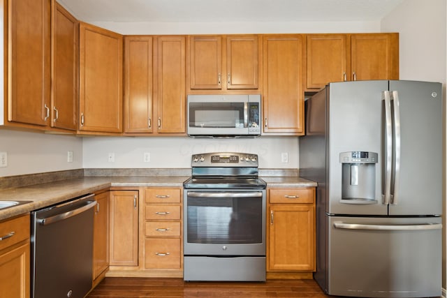 kitchen featuring appliances with stainless steel finishes and dark hardwood / wood-style flooring