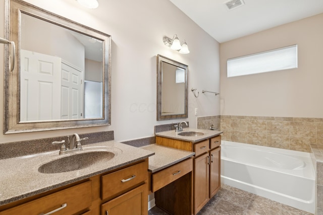 bathroom featuring tile patterned floors, a washtub, and vanity