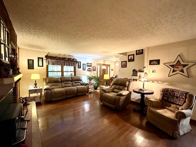 living room with a textured ceiling, dark wood-type flooring, and a brick fireplace