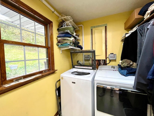 laundry area with washing machine and dryer and a textured ceiling