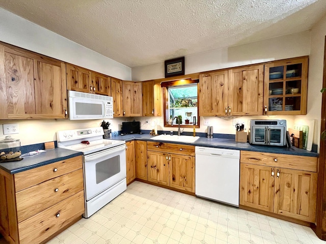 kitchen featuring a textured ceiling, sink, and white appliances